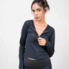Model wearing a black zip top in a standing pose, showcasing the front design.