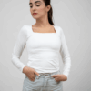 Model wearing a white square top in a standing pose, showcasing the front design.